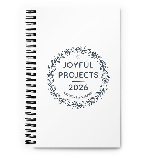 Spiral notebook with floral wreath design reading “Joyful Projects 2026 – Creating & Sharing.”