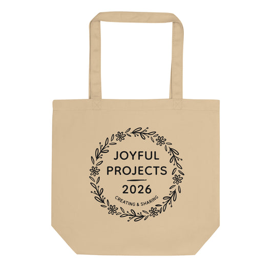 Organic cotton tote bag in natural oyster color featuring “Joyful Projects 2026” wreath design.