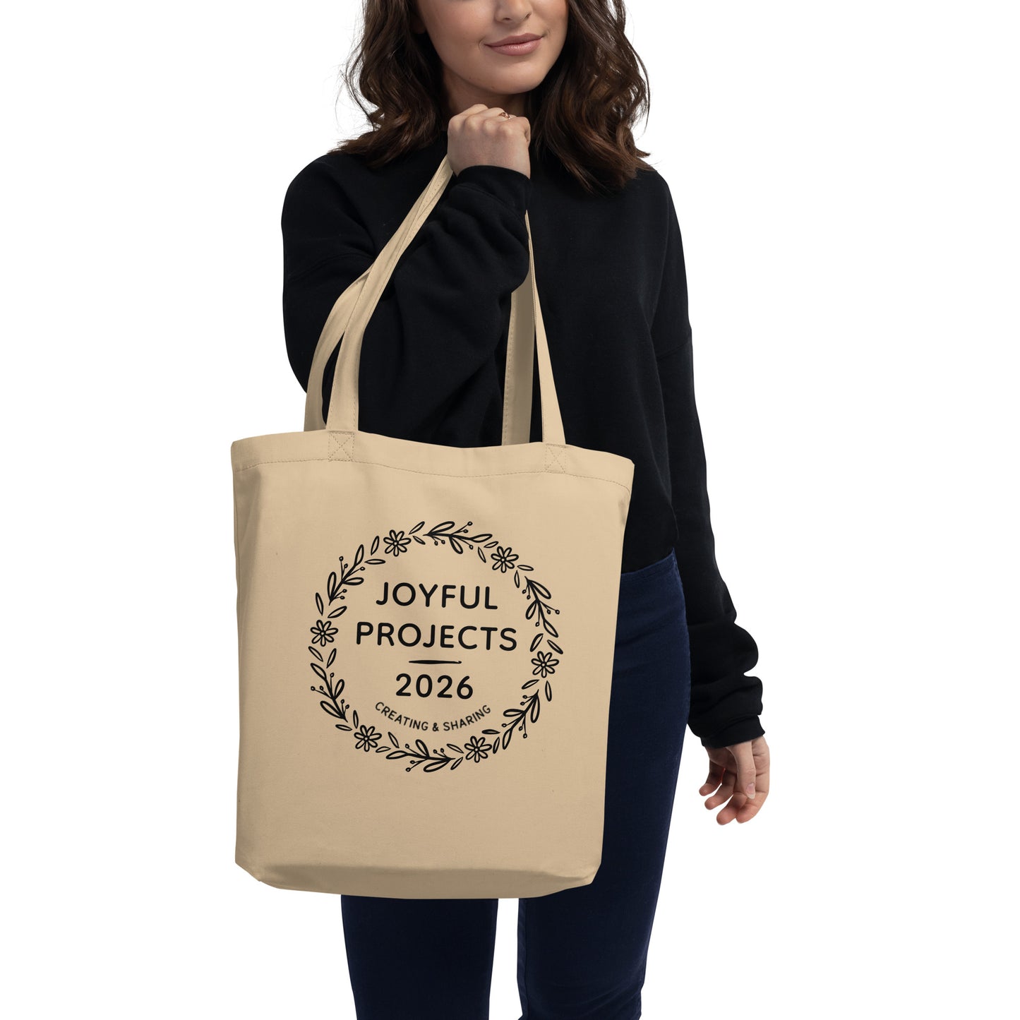 Person carrying a natural organic cotton tote bag with Joyful Projects 2026 design.