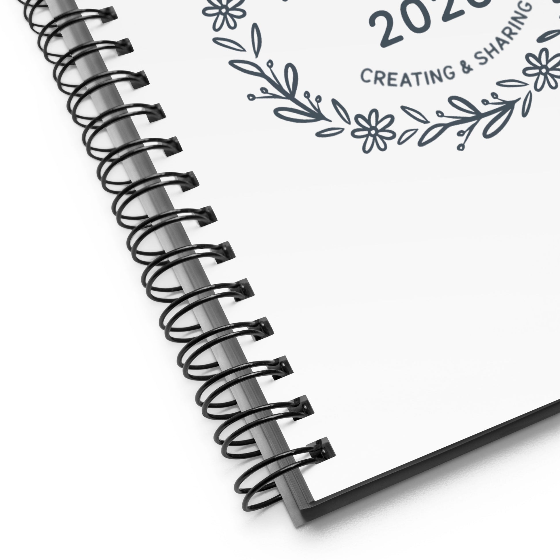 Close-up of black metal spiral binding on Joyful Projects notebook.